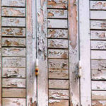 Ecaillage d'une peinture sur des volets en bois 